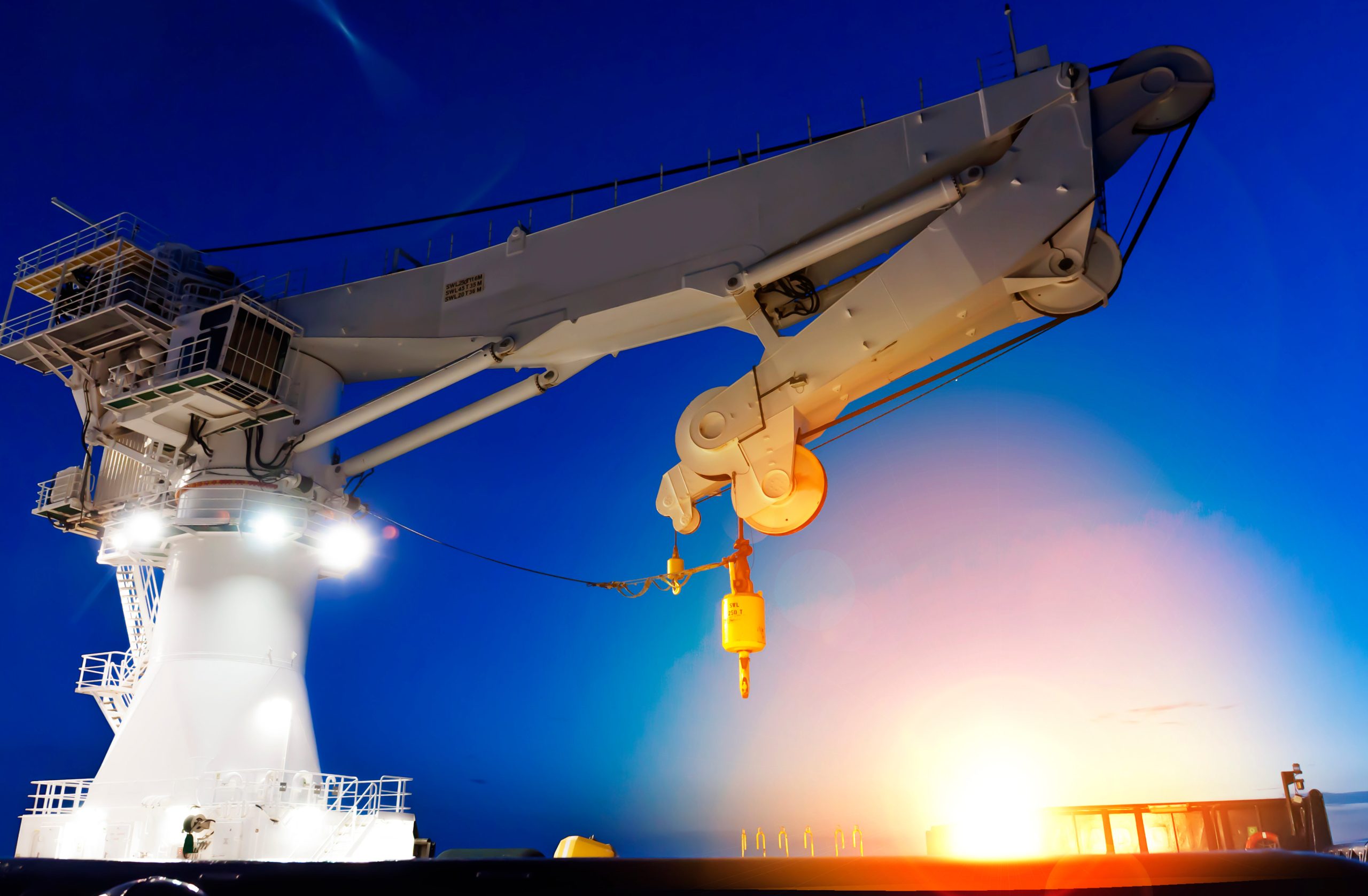 Offshore heavy lift crane at sea by night knuckle jib