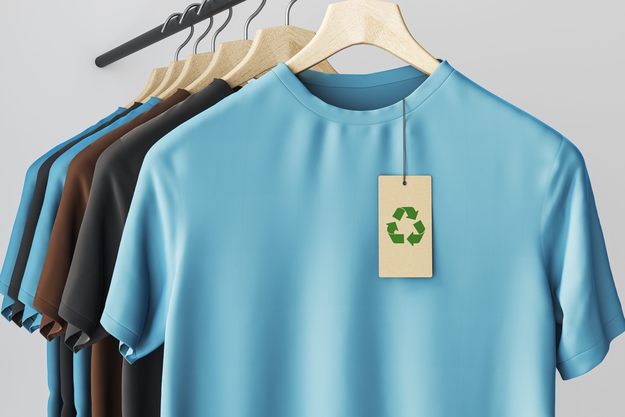 Eco-friendly tshirt rack with recycling tag on blank clean garments displayed in light retail background for sustainable branding concept mockup template store design retail scene. 3D Rendering